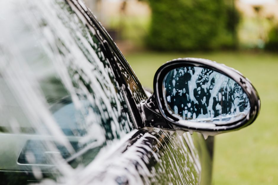Rich car wash soap foam applied to a luxury vehicle